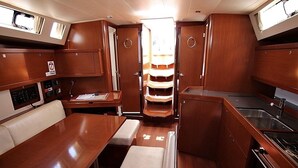 A compact galley with a dining table, bench seating, a stove, and a sink. - Sun-Kissed Sailing Adventure in Zadar, Croatia (Bibinje)