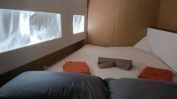 Un dormitorio con cama, almohadas y ventana.