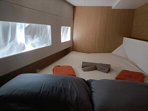A bedroom with a bed, pillows, and a window.