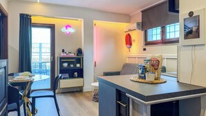 A modern kitchen with a dining area, a coffee station, and a view of the outside. - Secret Rooftop Suite – Tor Vergata Metro (Roma)