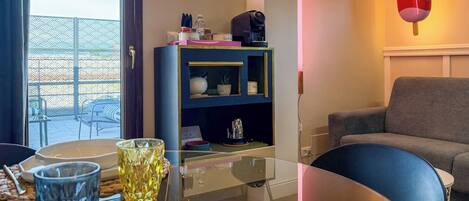 Una sala de estar moderna con una mesa de vidrio, un sofá, una estantería decorativa y un letrero de neón.