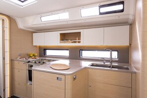 A compact kitchenette with a stove, sink, and storage cabinets.