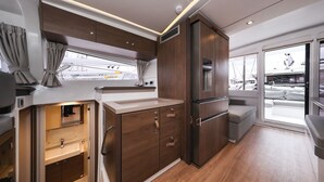 A compact kitchen with wooden cabinets, a built-in sink, and a window overlooking the deck. - Sun-kissed Sailing Adventure in Split-Dalmatia, Croatia (Trogir)