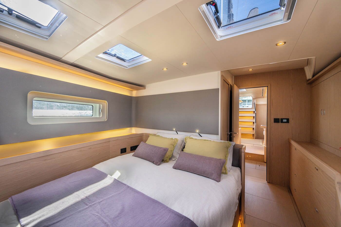 Ein modernes Interieur mit einem Bett, Oberlichtern und Blick ins Freie.