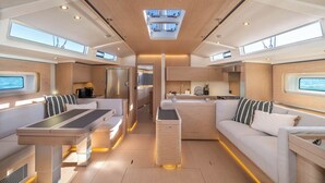 A modern interior with a central dining area, kitchen, and seating space. - Sun-Kissed Sailing Adventure in Split, Croatia (Kaštel Gomilica)