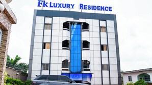 Un edificio con un cartel que dice 'Ek Luxury Residence' y un SUV estacionado.