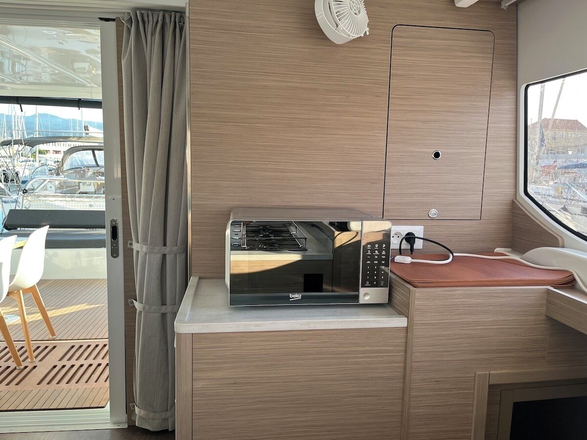 Une petite cuisine équipée d’un four à micro-ondes, d’une prise électrique et d’une fenêtre donnant sur les bateaux.