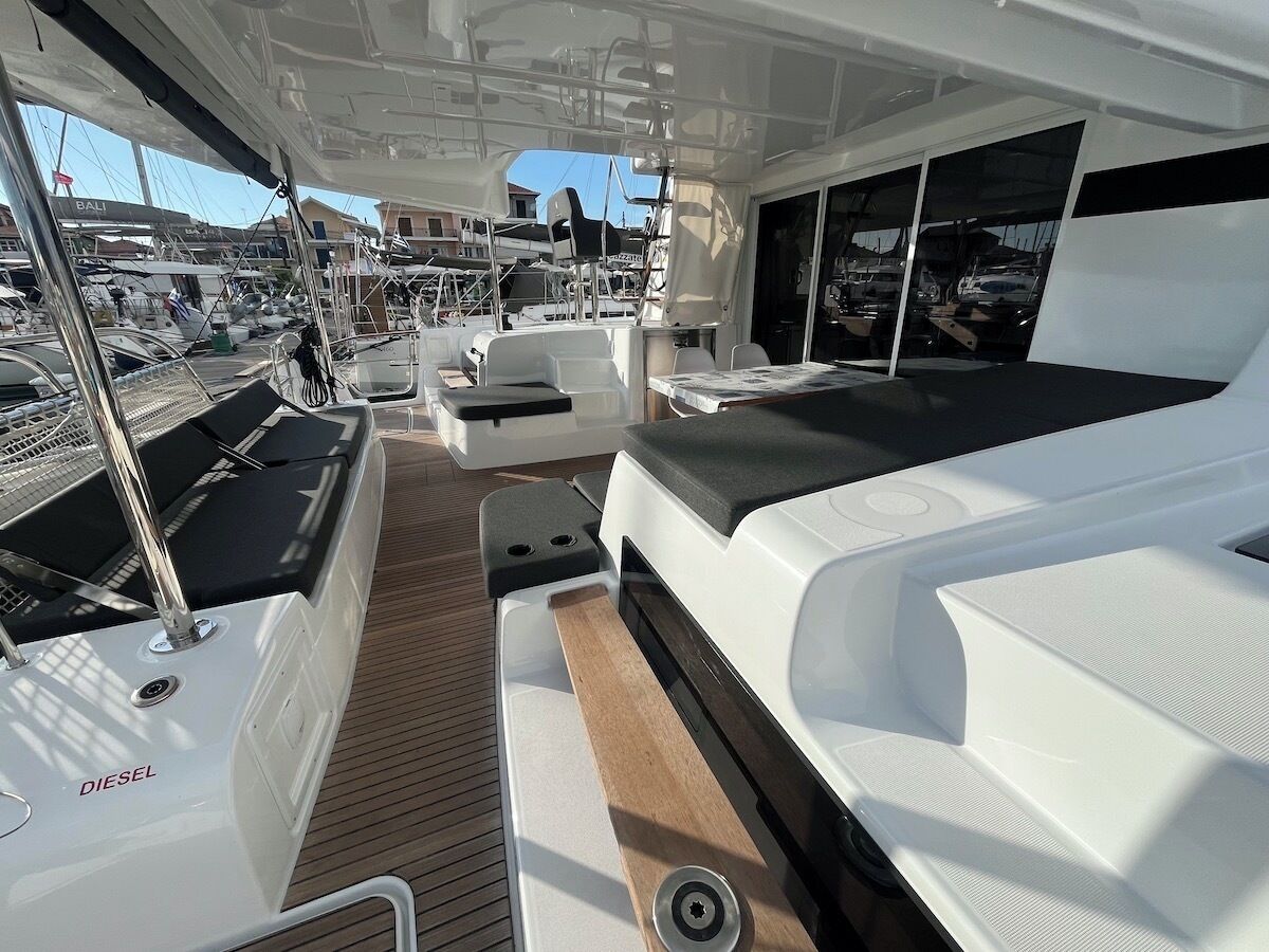 A boat deck with seating, a table, and a view of the marina.