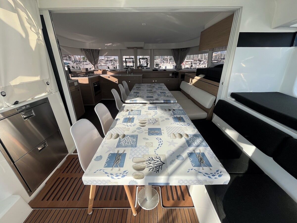 A dining area with a table, chairs, and a view of the marina.