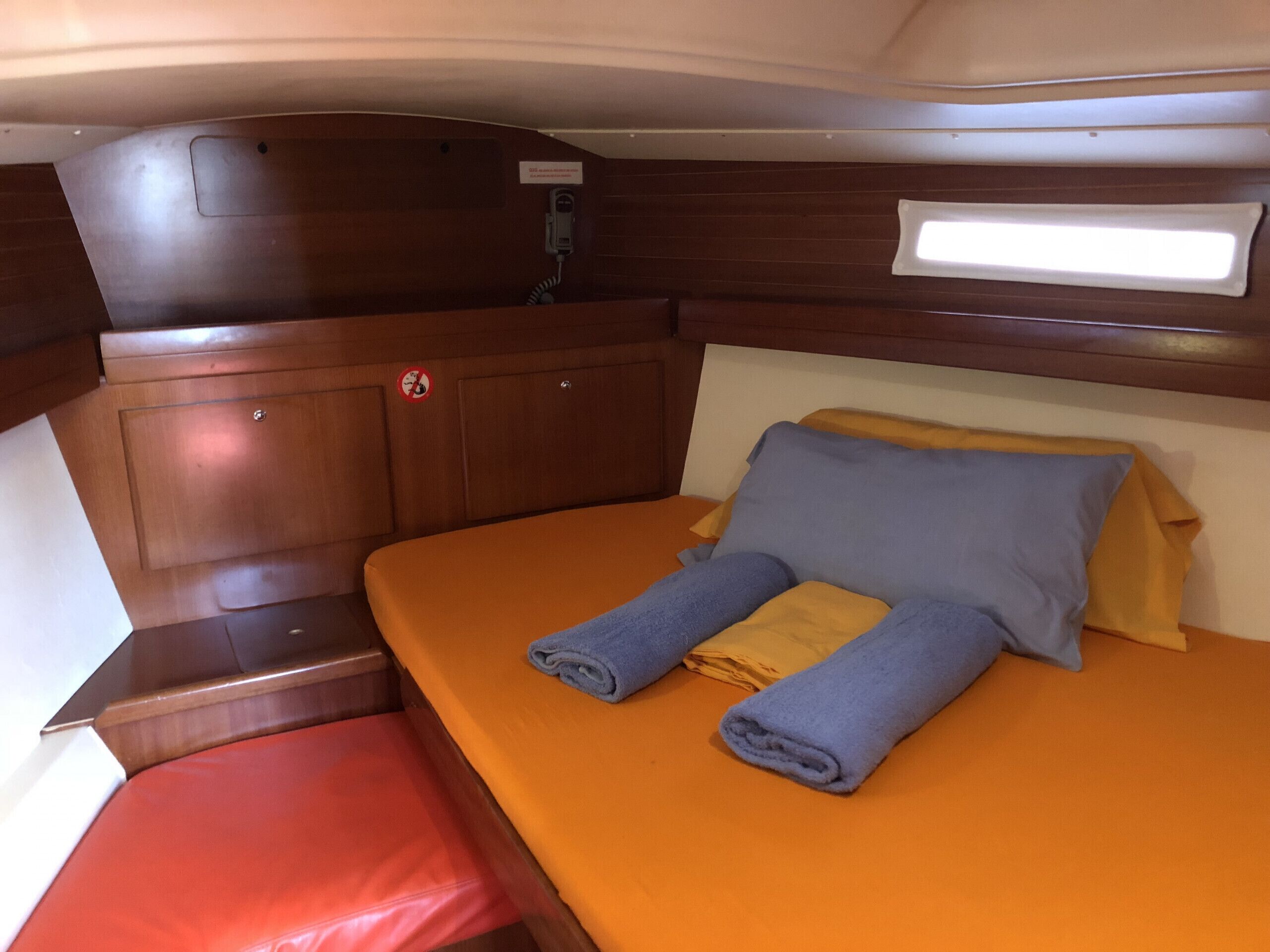 Ein gemütliches Blockhaus mit Bett, Tisch und Bank.