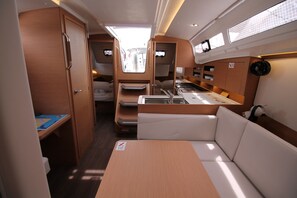 A compact RV interior with a kitchenette, seating area, and storage cabinets. - Sun-Kissed Sailing Adventure in Zadar, Croatia (Biograd na moru)