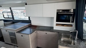 A compact kitchen with a built-in oven, a sink, and cabinets. - Sun-kissed Sailing Adventure in Split-Dalmatia, Croatia (Seget Donji)