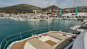 A yacht docked at a marina with a view of the town in the background. - Sun-kissed Sailing Adventure in Split-Dalmatia, Croatia (Seget Donji)