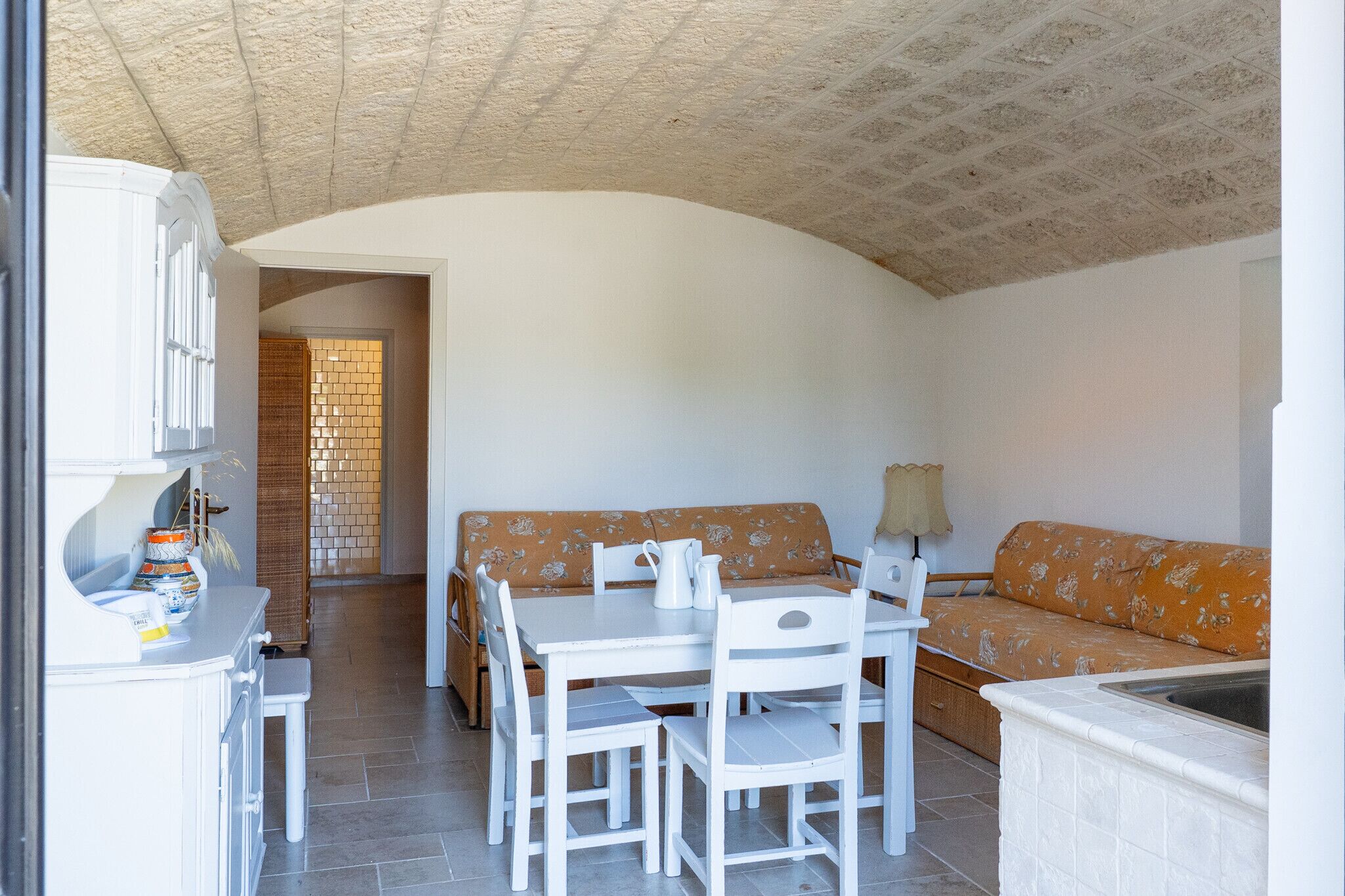 A compact living space with a dining area, a sofa, and a kitchen counter.