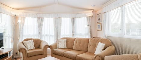 A living room with a sofa set, a coffee table, and a TV stand.