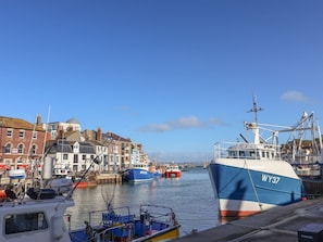 A harbor with boats, a building labeled 'The George Inn,' and a clear sky. - The Hideaway (Weymouth)