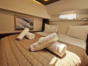 Een hotelkamer met een groot bed, een schilderij aan de muur en een raam met jaloezieën.