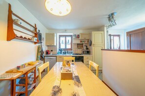 Cocina compacta con mesa, sillas y electrodomésticos básicos.
