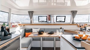 Une petite cuisine fonctionnelle comprenant un coin repas, un coin cuisine et un espace salon.