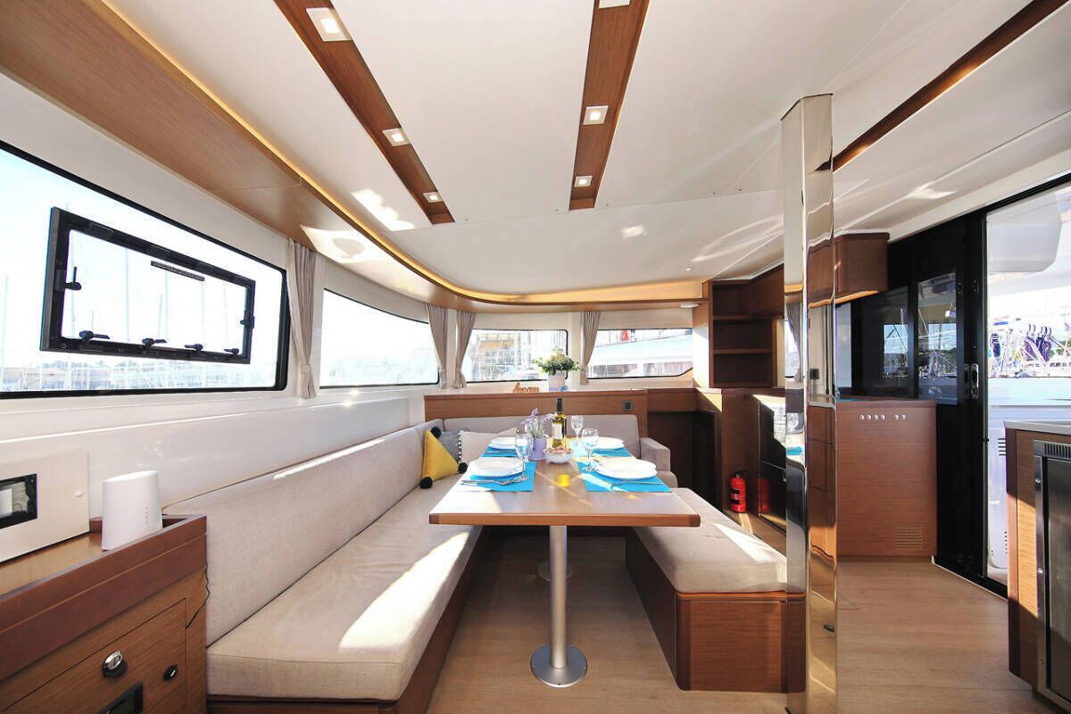 L’intérieur d’un bateau comprend un coin repas, des sièges, une cuisine et une grande fenêtre.