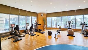 Ein Fitnessraum mit Cardiogeräten, einem Rudergerät und einem großen Trainingsball.
