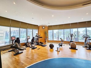 Ein Fitnessraum mit Cardiogeräten, einem Rudergerät und einem großen Trainingsball.