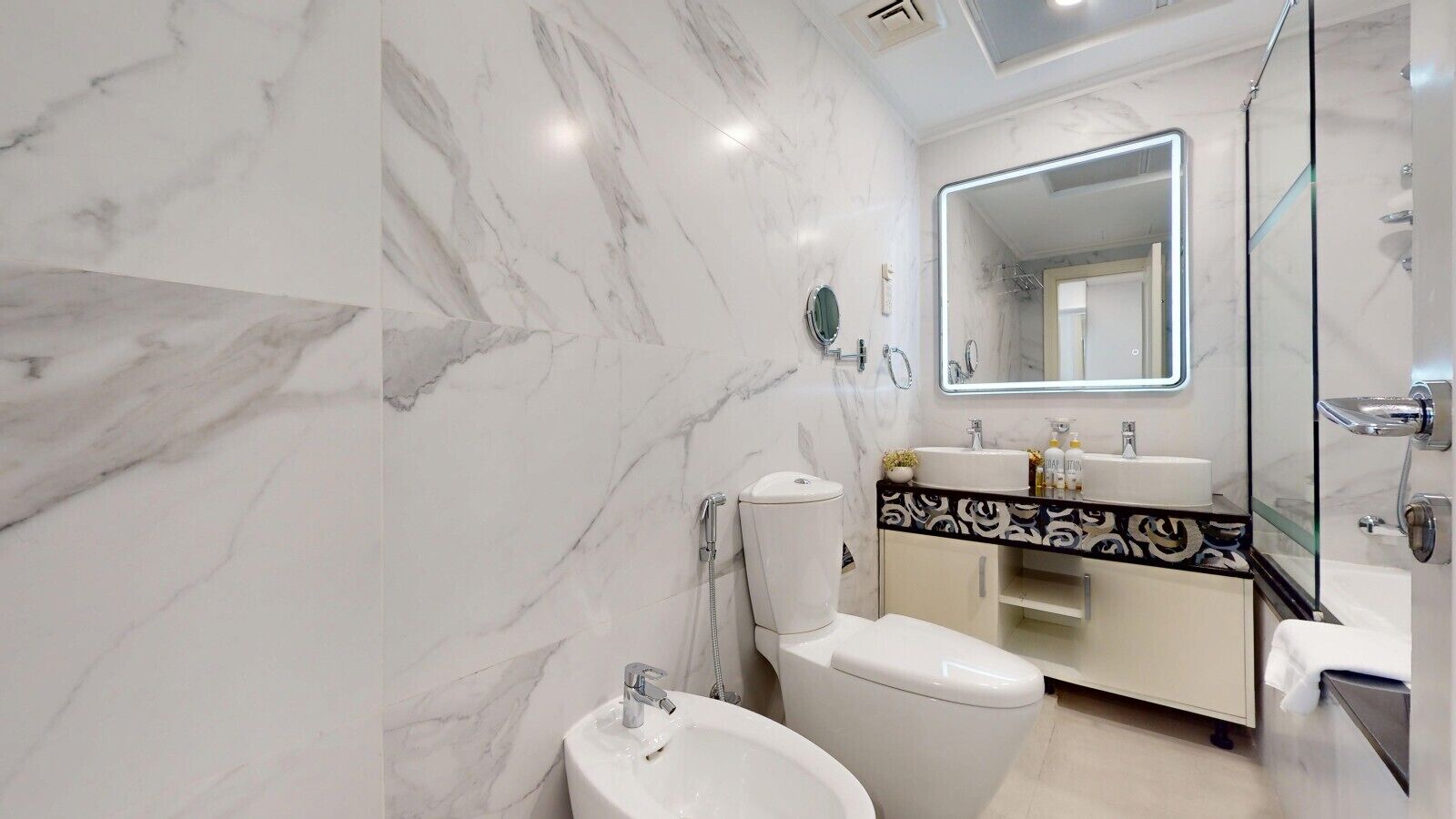Ein modernes Badezimmer mit Toilette, Bidet, Waschbecken und Spiegel.