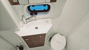 A bathroom with a white sink, a toilet, and a mirror.