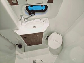 A bathroom with a white sink, a toilet, and a mirror.