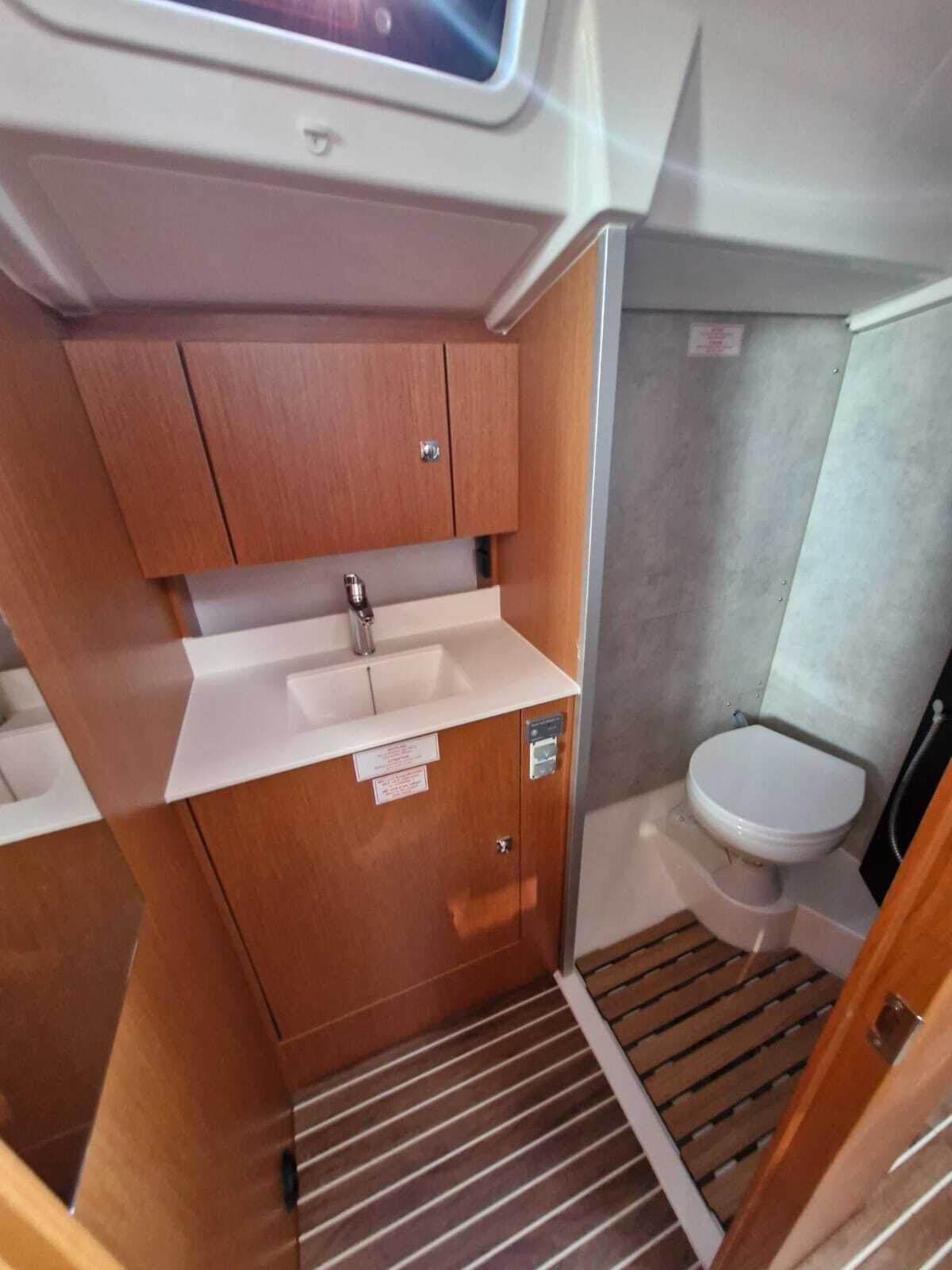 Een kleine badkamer met een wastafel, toilet en douche.