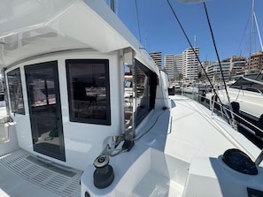 A boat's deck with windows, a steering wheel, and a railing. - Sun-Kissed Sailing Adventure in Islas Baleares, Mallorca (Palma)
