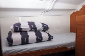 A bunk bed with two pillows featuring anchor designs, a wooden headboard, and a white mattress. - Sun-Kissed Sailing Adventure in Zadar, Croatia (Biograd na moru)