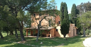 A two-story building with a tiled roof, surrounded by trees and a grassy area. - Double Room with Private Bathroom 1 (Stazzano)