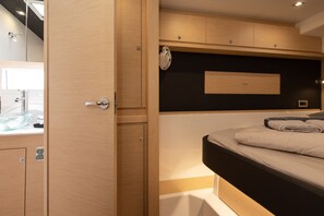 Quarto moderno com guarda-roupa de madeira, mesa de cabeceira e cabeceira preta.