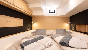 A modern bedroom with a large bed, two bedside tables, a built-in wardrobe, and a skylight. - Sun-Kissed Sailing Adventure in Sibenik, Croatia (Primošten)