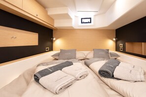 Quarto moderno com uma cama grande, duas mesas de cabeceira, um guarda-roupa embutido e um claraboia.
