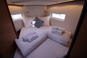Ein kleines, privates Zimmer mit einem Bett, zwei Fenstern und einem kleinen Tisch.