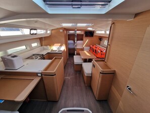 A compact, well-lit interior with a kitchenette, seating area, and storage compartments. - Sun-Kissed Sailing Adventure in Zadar, Croatia (Biograd na moru)