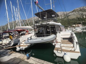 Ein Yachthafen mit vertäuten Booten, darunter ein weißes Boot namens 'MEA COULE PAS' und 'LA ROCHELLE'.