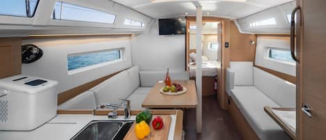 A compact kitchen with a sink, a microwave, and a small dining area with a table and chairs.