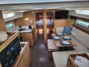 A compact RV interior with a kitchenette, dining area, and sleeping quarters. - Sun-Kissed Sailing Adventure in Zadar, Croatia (Biograd na moru)