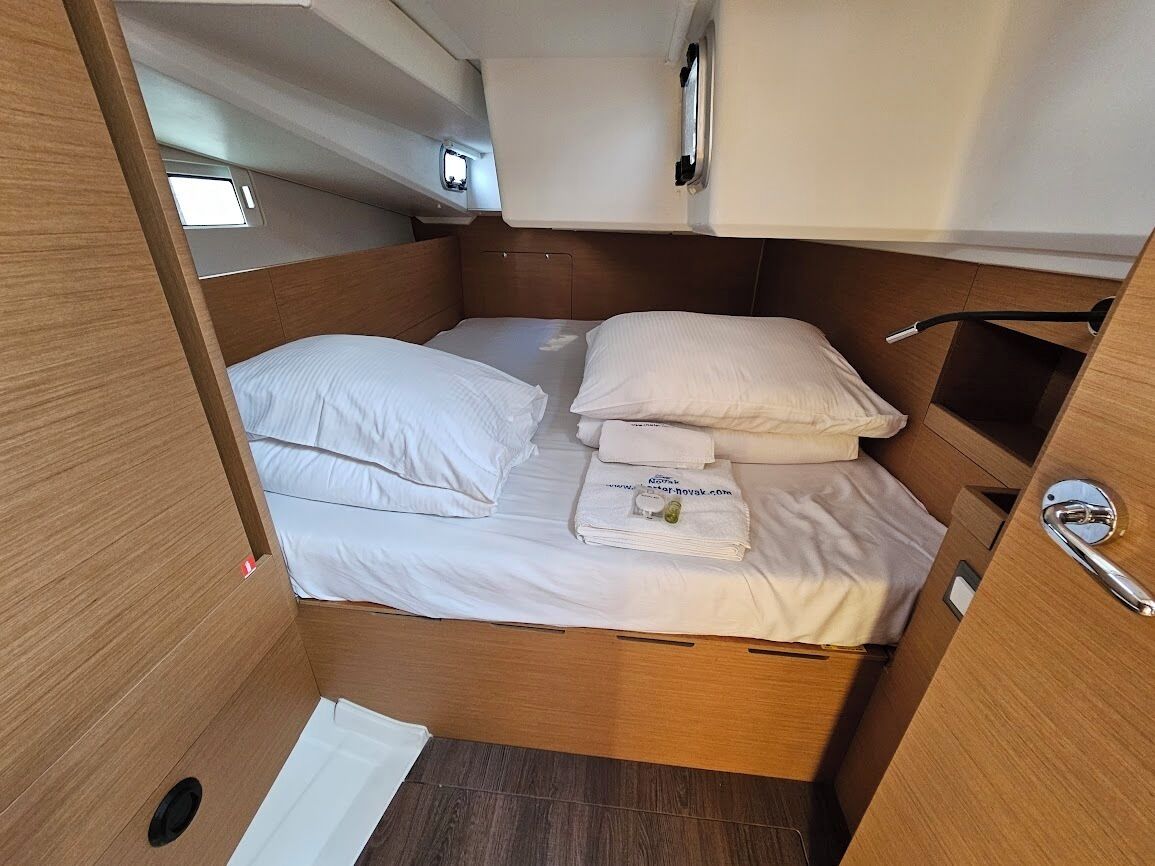 A compact, well-lit interior with a bunk bed, a small window, and a door with a handle.