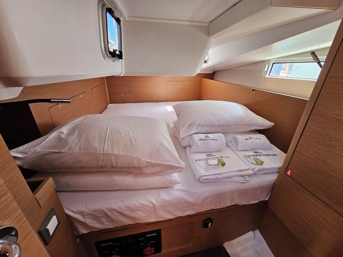 A compact bed with a headboard, a control panel below, and a window above.