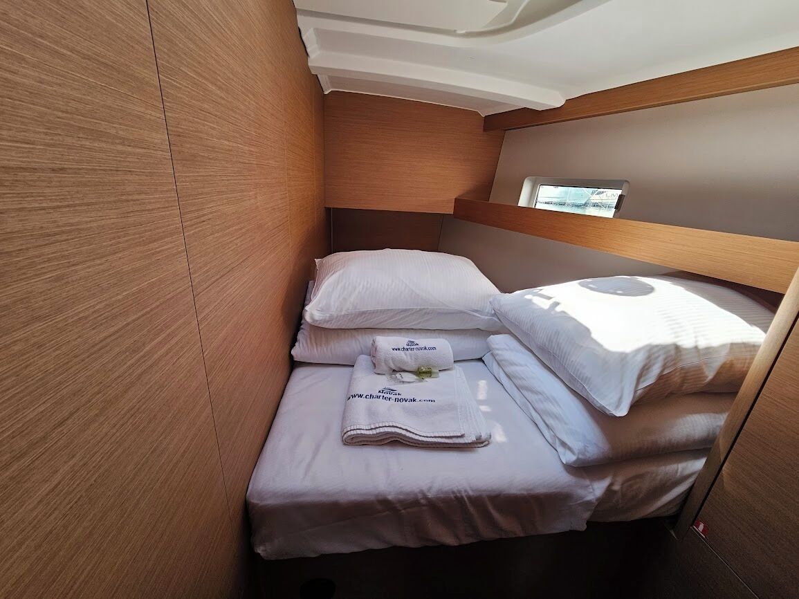Una cabaña pequeña y luminosa, con cama, almohadas y toallas ordenadas.