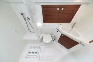 Ein kleines Badezimmer mit Dusche, Toilette und Badewanne.