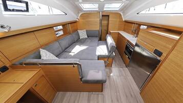 A compact interior with a sofa, a small kitchen, and a window.