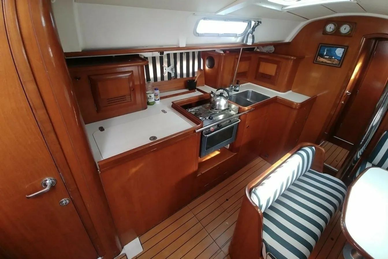 A compact galley with a stove, sink, and storage cabinets.
