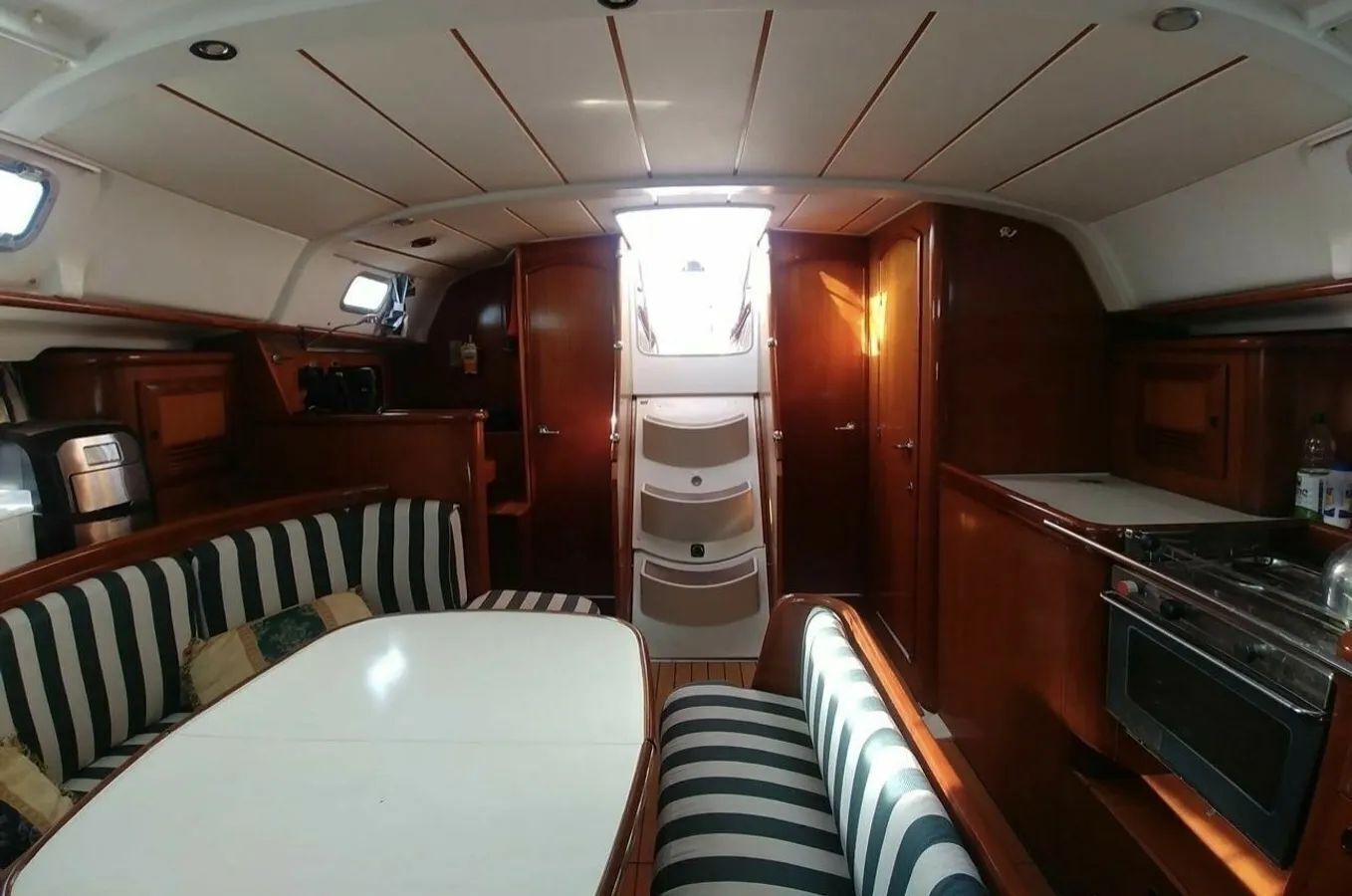 A compact interior with a central seating area, a small kitchenette, and a window providing natural light.
