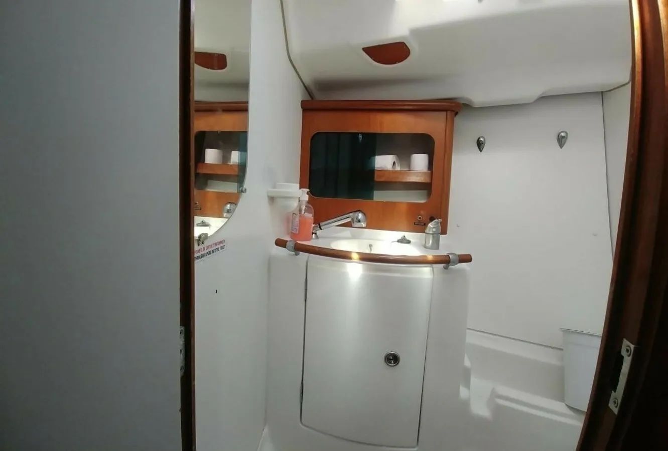 A compact bathroom with a sink, mirror, and storage cabinet.
