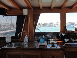Eine kleine Pantryküche mit Spüle, Herd und Fenster mit Blick auf eine Marina.